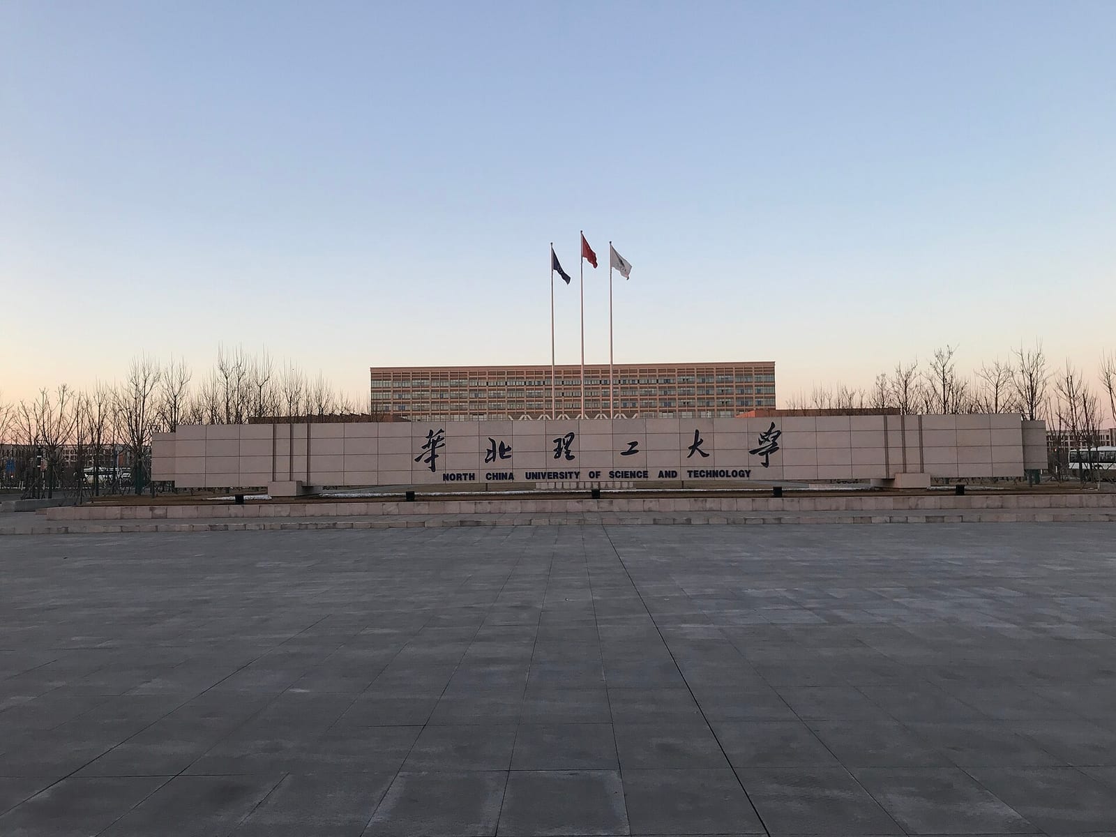 The name wall of North China University of Science and Technology, with flags behind