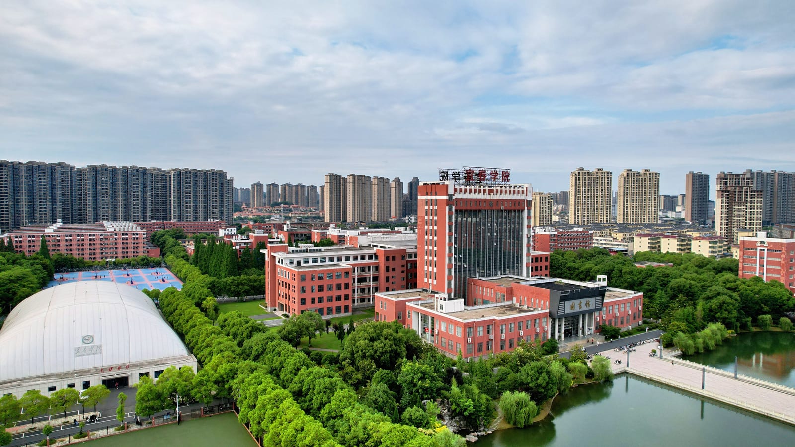 Yichun University from the air — teaching blocks, the sports dome and the campus lake